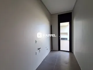 Hall de entrada com paredes brancas e piso de concreto.