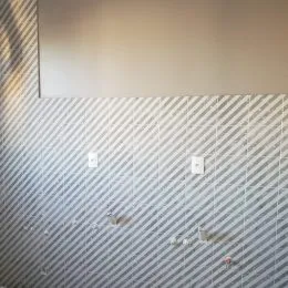 Foto de uma parede com revestimento listrado diagonal em um imóvel.