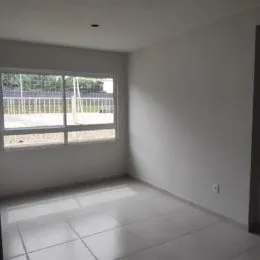 Vista interna de um cômodo com piso de cerâmica e janela lateral.