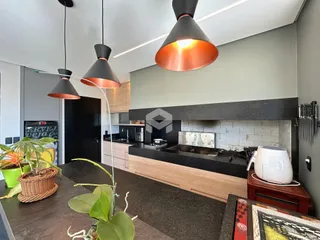 Imagem de uma cozinha moderna com armários de madeira e bancadas escuras.