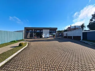 Fachada de uma residência moderna com área pavimentada na frente.