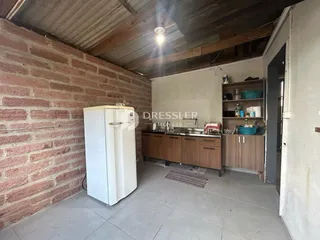 Interior de uma sala com parede de tijolos aparentes e piso de cerâmica.