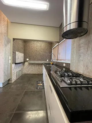 Foto de uma cozinha com bancada escura e revestimento de azulejos.