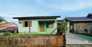 Fachada de uma residência em Lajeado, Brasil, com parede verde e telhado de metal.
