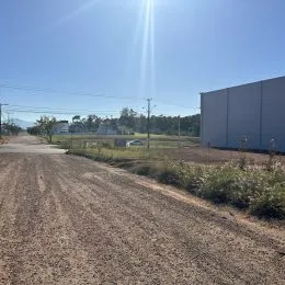 Vista externa de uma estrada de terra em uma área aberta.