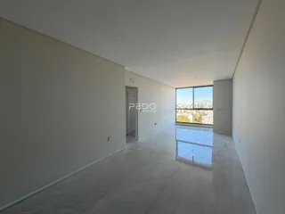 Ambiente interno de uma sala ampla com vista para a cidade.