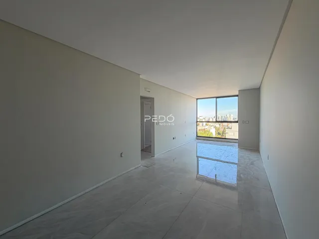 Ambiente interno de uma sala ampla com vista para a cidade.