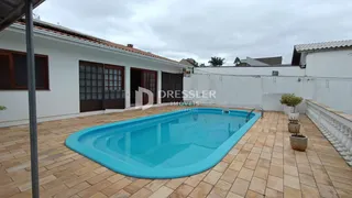 Foto da fachada de uma casa com piscina e área externa em Lajeado.