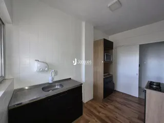 Vista da cozinha com bancada e armários em madeira.