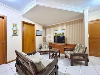 Sala de estar com móveis de madeira e piso cerâmico em um imóvel no Brasil.