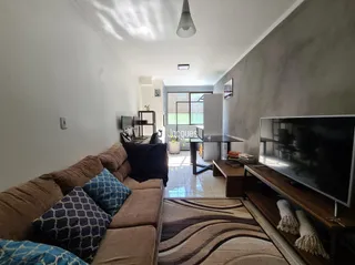 Sala de estar com sofá e televisão em um apartamento.