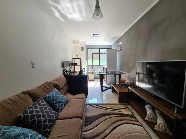 Sala de estar com sofá e televisão em um apartamento.