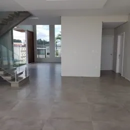 Ambiente interno amplo com piso de porcelanato claro e paredes brancas.