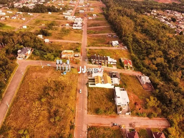 Vista aérea de uma área rural com estradas de terra e vegetação.