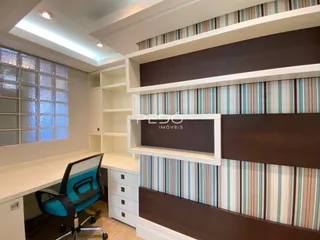 Ambiente interno de escritório com estantes e painéis decorativos.