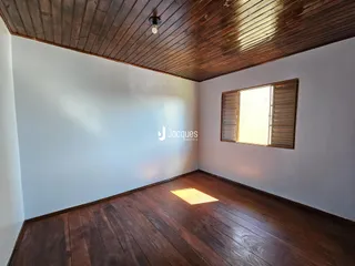 Ambiente interno com piso de madeira escura e teto de madeira.