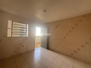 Hall de corredor com piso de cerâmica e paredes brancas.