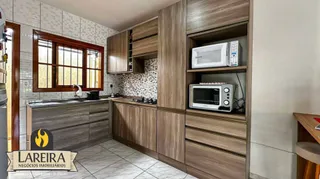 Foto de uma cozinha com armários de madeira e revestimento de azulejos.