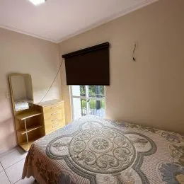 Foto de um quarto com cama e cabeceira escura.