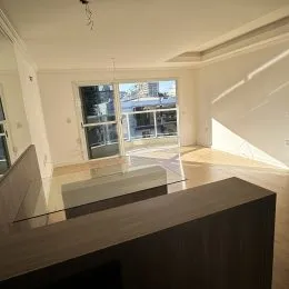 Vista de uma cozinha moderna com bancada e portas de vidro.