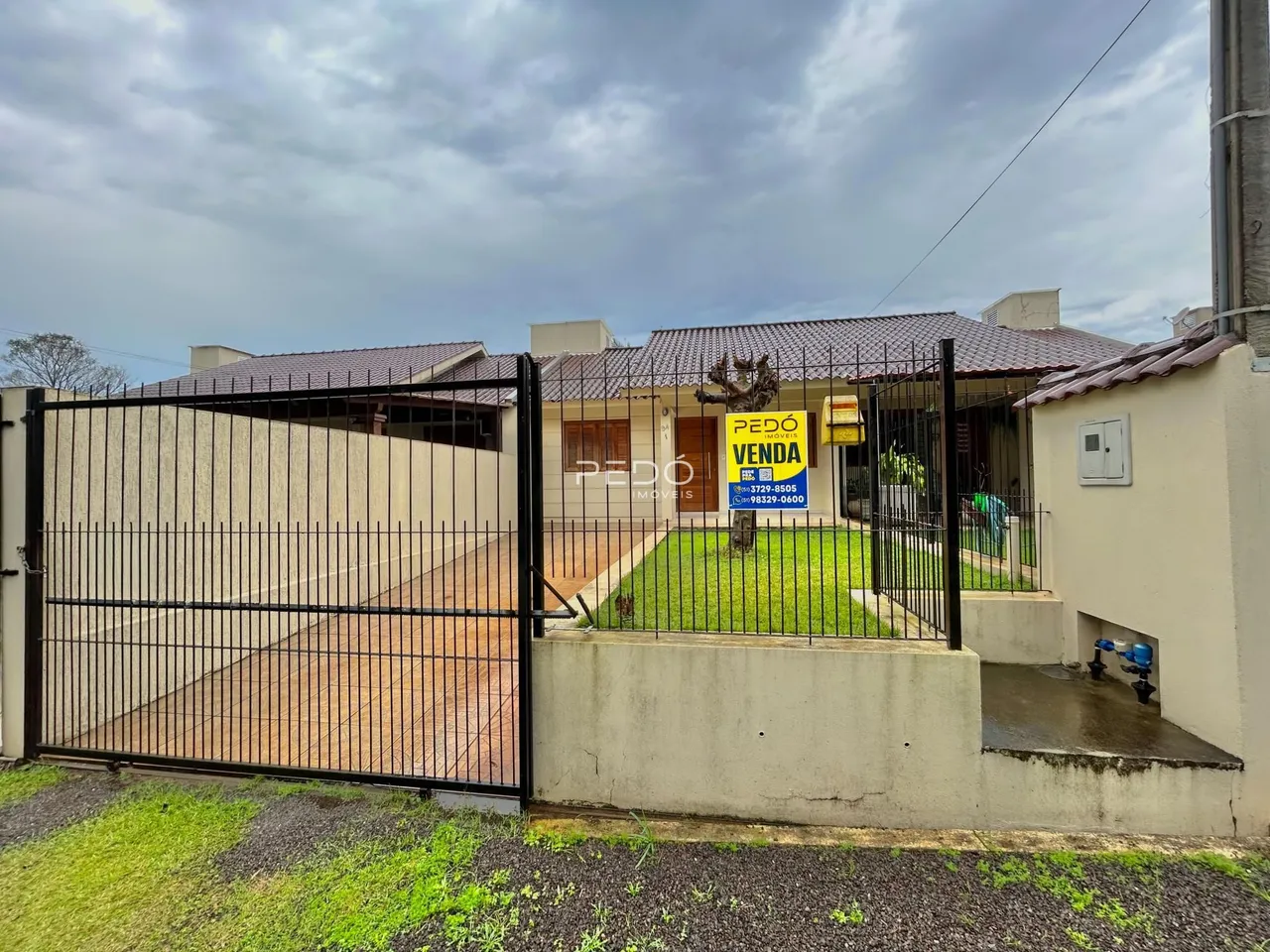 Fachada de uma residência com portão de ferro e muro em Lajeado, Brasil.