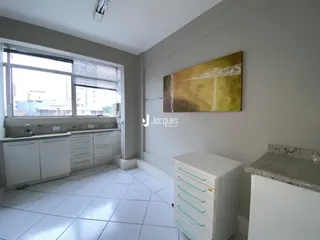 Ambiente interno com piso de cerâmica e armários brancos.