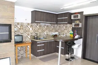 Foto de uma cozinha com armários de madeira e revestimento cerâmico.