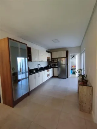 Cozinha com armários brancos e bancadas escuras em um imóvel.