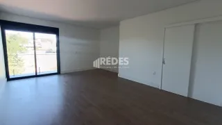 Sala de estar com piso de madeira e porta de vidro.