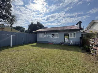Fachada de uma casa com jardim gramado e cerca no Brasil.