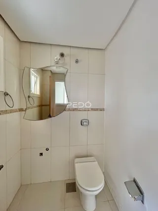 Foto de um banheiro com paredes revestidas de azulejos brancos.