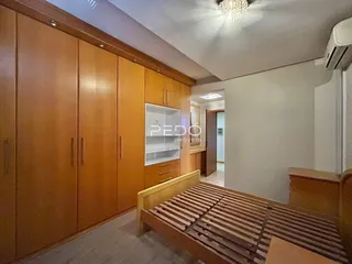 Quarto com armários de madeira e cama de madeira.