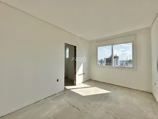 Interior de um cômodo com paredes brancas e piso de concreto cru.