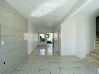 Corredor interno com piso de cerâmica claro e paredes brancas.