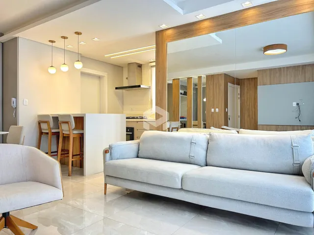 Sala de estar moderna com sofá grande e detalhes em madeira.
