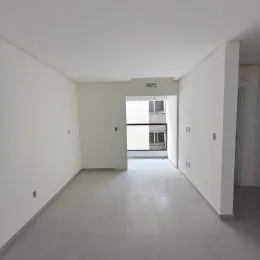 Foto de um corredor interno com paredes brancas e piso claro.