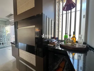 Vista da cozinha moderna com armários escuros e bancada de granito.