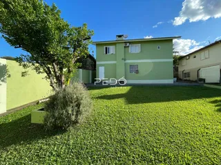 Fachada de uma casa em Lajeado, Brasil, com um grande jardim gramado na frente.