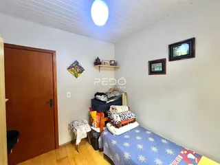 Quarto com cama e decoração nas paredes brancas.