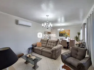 Sala de estar com sofá grande e luminária de cristal.