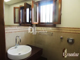 Foto de um banheiro com pia e revestimento de cerâmica.