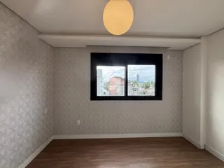 Sala com parede texturizada e janela com vista para a cidade.