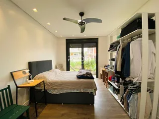 Quarto com cama, escrivaninha e armário em um ambiente claro.