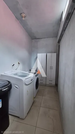 Foto de um ambiente interno com máquinas de lavar e armários brancos.