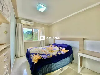 Quarto com cama e janela bem iluminado.