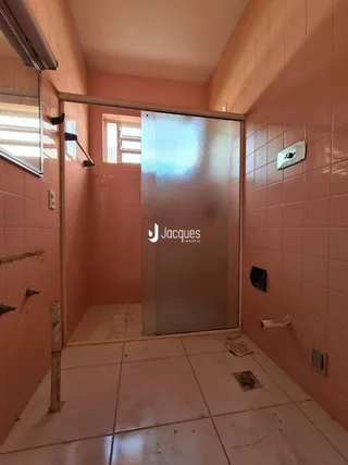 Vista de um corredor interno com paredes em tom salmão.