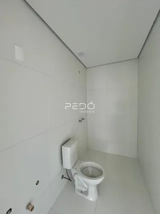 Foto de um banheiro interno com piso e paredes brancas.