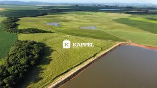 Vista aérea de uma propriedade rural com campos verdes e um corpo d'água.