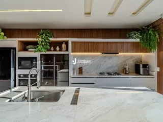 Cozinha moderna com armários e bancadas em mármore.