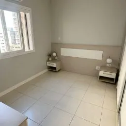 Quarto com paredes claras e piso de cerâmica.